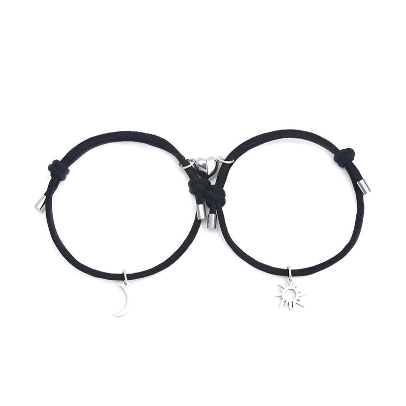 Duo de bracelets cordon noirs avec charms soleil et lune argentés, fermoir métal.