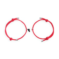 Duo de bracelets rouges en cordon avec cœurs aimantés noirs au centre.