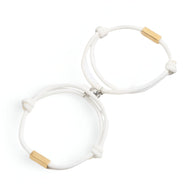 Duo de bracelets cordon blancs avec fermoirs en acier inoxydable doré, style minimaliste et élégant.