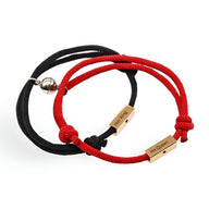 Duo de bracelets cordon rouge et noir en acier inoxydable avec plaques gravées personnalisées.