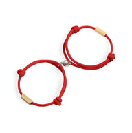 Duo de bracelets cordon rouge avec fermoir et détails en acier inoxydable doré.