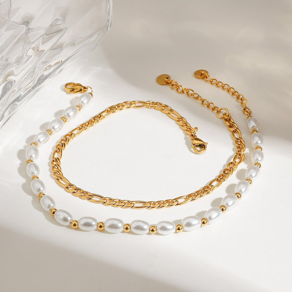 Duo de bracelets de cheville or, chaîne fine et perles d'eau douce avec petits détails dorés.