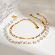 Duo de bracelets de cheville or, chaîne fine et perles d'eau douce avec petits détails dorés.