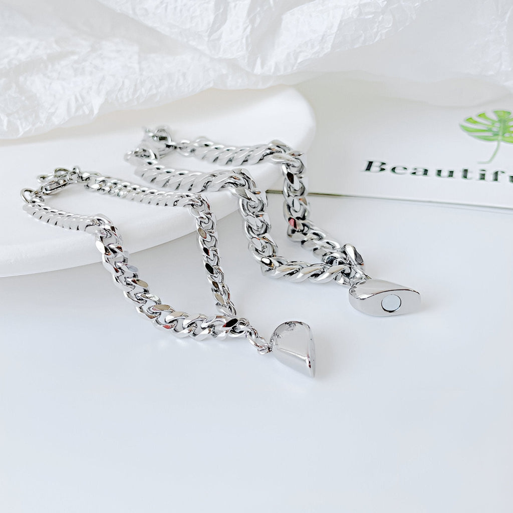 Duo de bracelets en acier inoxydable argenté avec pendentifs cœurs aimantés, style chaîne épaisse.