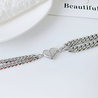 Duo de bracelets en acier inoxydable argent avec pendentif cœur aimanté, design mixte élégant.