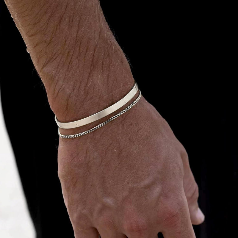 Duo de bracelets homme en acier inoxydable, jonc lisse et maille fine argentée.