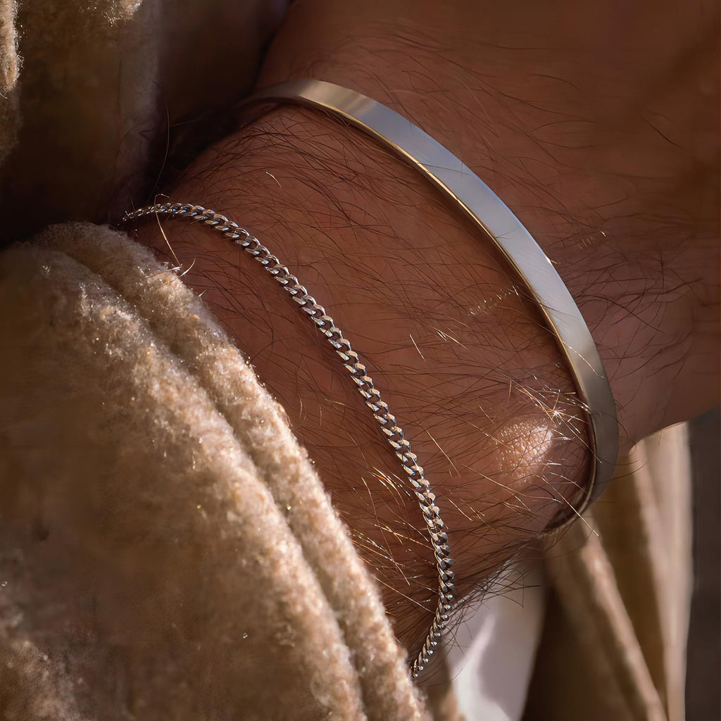 Duo de bracelets homme en acier inoxydable, jonc lisse argenté et maille fine en chaîne argentée.