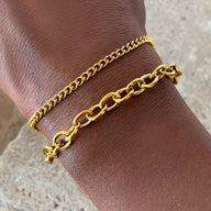 Duo de bracelets en acier inoxydable doré, maillons fins et larges, modèle Priscilla, porté au poignet féminin.