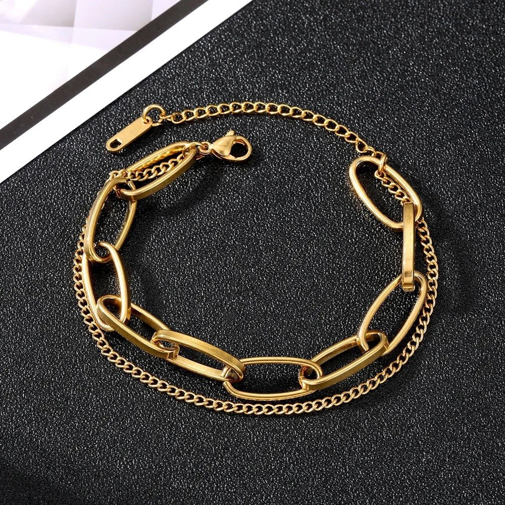 Duo de bracelets en acier inoxydable doré, un à maillons larges et l'autre fin avec chaîne ajustable.