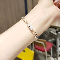 Bracelet en acier inoxydable argenté avec breloque lune sur chaîne fine pour poignet féminin.