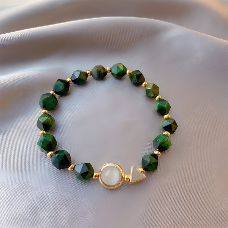 Bracelet vert en perles facettées œil de tigre avec fermoir doré et pierre blanche centrale.