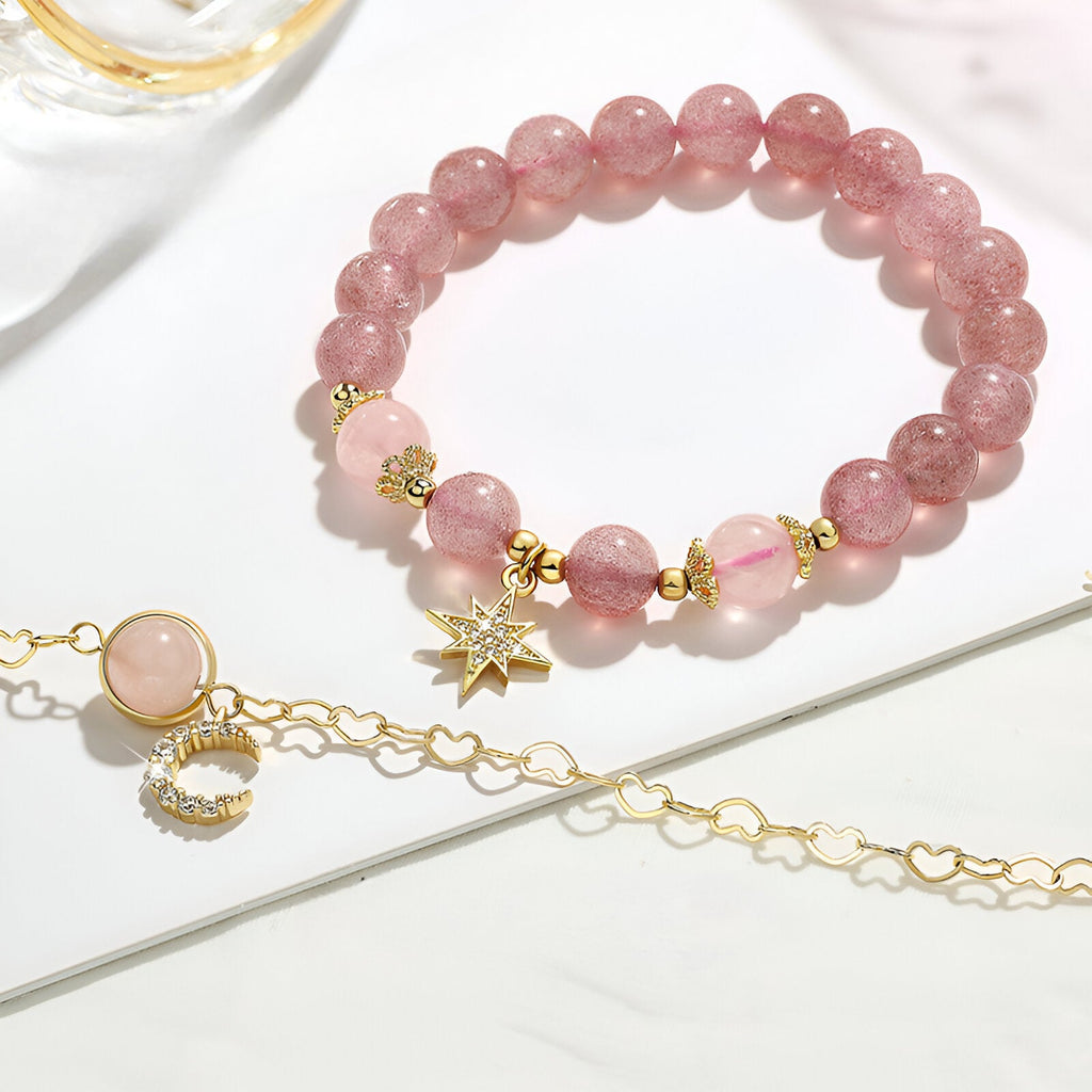 Duo de bracelets roses en pierres de cristal avec pendentifs étoile et lune dorés, style délicat et féminin.