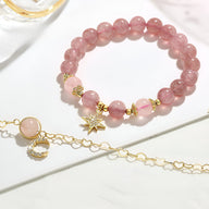 Duo de bracelets roses en pierres de cristal avec pendentifs étoile et lune dorés, style délicat et féminin.