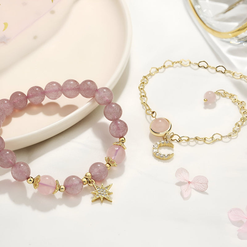 Duo de bracelets rose en pierres de cristal avec charms étoile et lune en métal doré.
