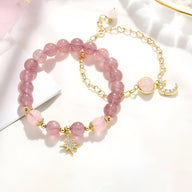 Duo de bracelets rose en pierres de cristal avec étoiles et lune dorées, modèle Astrée pour femme.