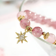 Duo de bracelets roses en pierres de cristal avec pendentifs étoile et lune dorés sertis de cristaux brillants.