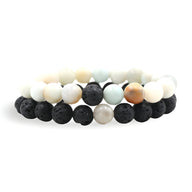 Duo de bracelets mixte avec pierres naturelles blanches, noires en lave et perle irisée blanche.