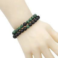 Duo de bracelets en perles noires mat et malachite verte, style mixte, modèle Blaire sur poignet pâle.