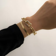 Duo de bracelets mousqueton en acier inoxydable doré, chaîne épaisse et bracelet lisse rigide.