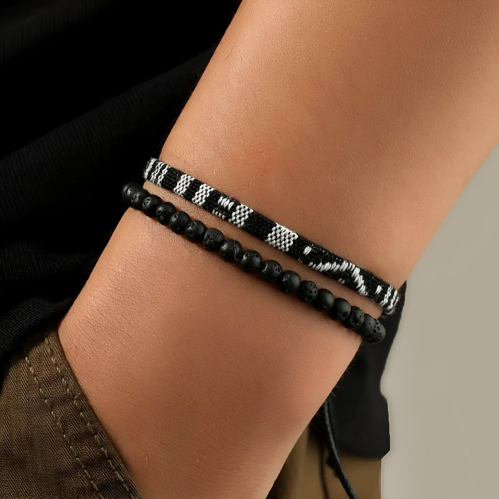 Duo de bracelets noirs pour homme, l'un en perles naturelles, l'autre en fil ciré avec motifs blancs tibétains.