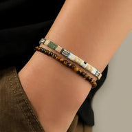 Duo de bracelets tibétains homme avec perles œil de tigre et tissage beige motifs bleus et noirs.