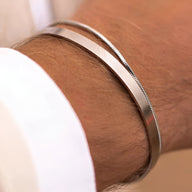 Duo de bracelets homme en acier inoxydable, jonc lisse et maille fine, finition brillante.