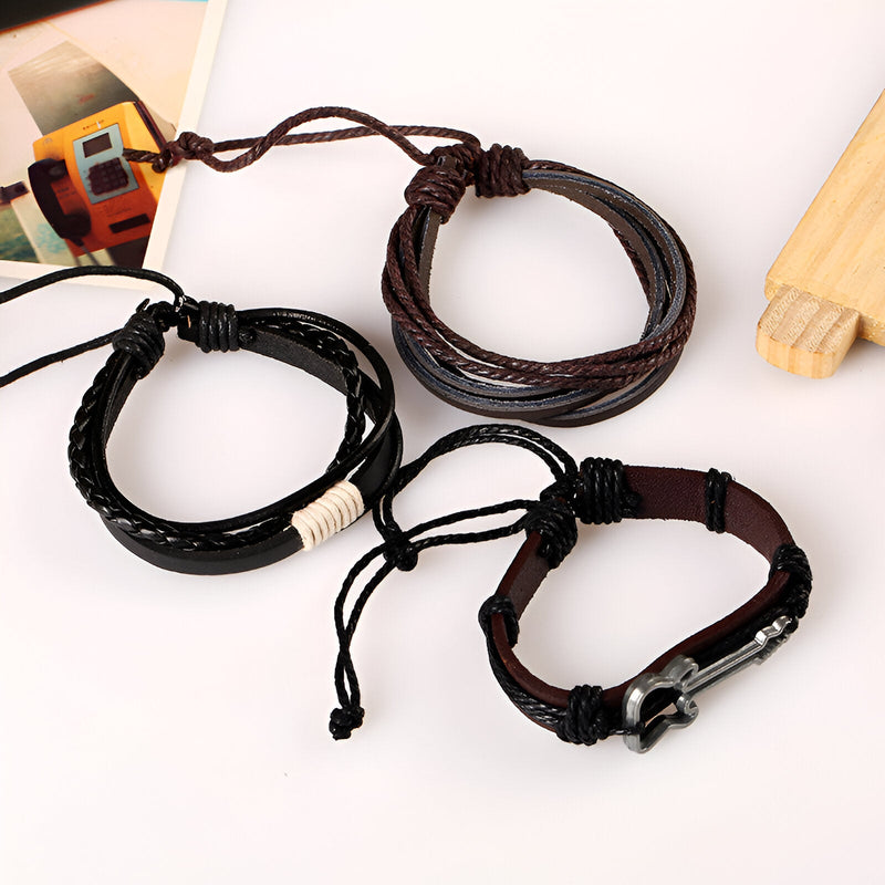 Ensemble de 3 bracelets en cuir marron et noir avec cordons réglables, dont un avec charm guitare en métal.