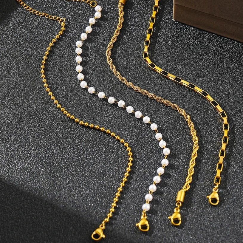 Ensemble de 4 bracelets femmes en acier inoxydable, finitions or et perles blanches, styles variés.