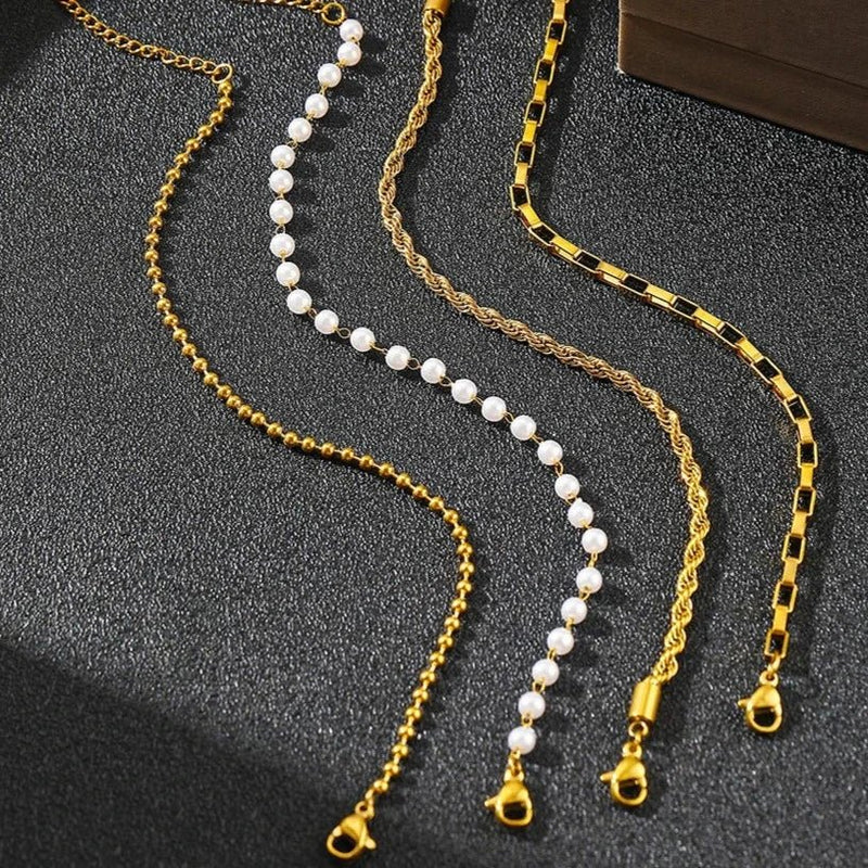 Ensemble de 4 bracelets femmes en acier inoxydable, finitions or et perles blanches, styles variés.