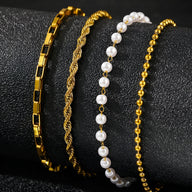 Ensemble de 4 bracelets dorés en acier inoxydable avec perles blanches et mailles variées pour femme.