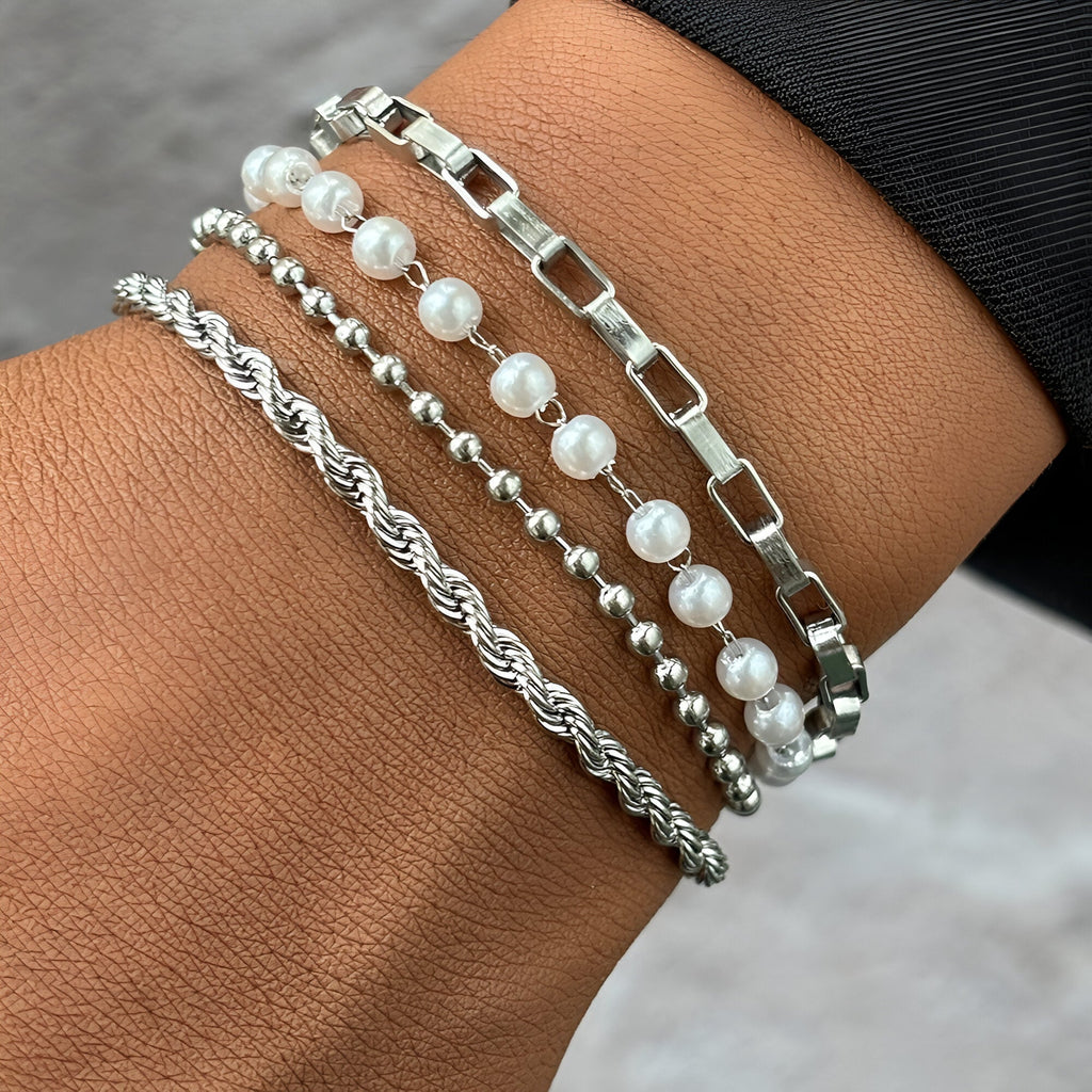 Ensemble de 4 bracelets femme en acier inoxydable argenté, perles blanches et maillons variés.