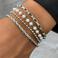 Ensemble de 4 bracelets femme en acier inoxydable argenté, perles blanches et maillons variés.