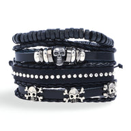Ensemble de quatre bracelets noirs en cuir et bois avec têtes de mort en métal argenté, style masculin.