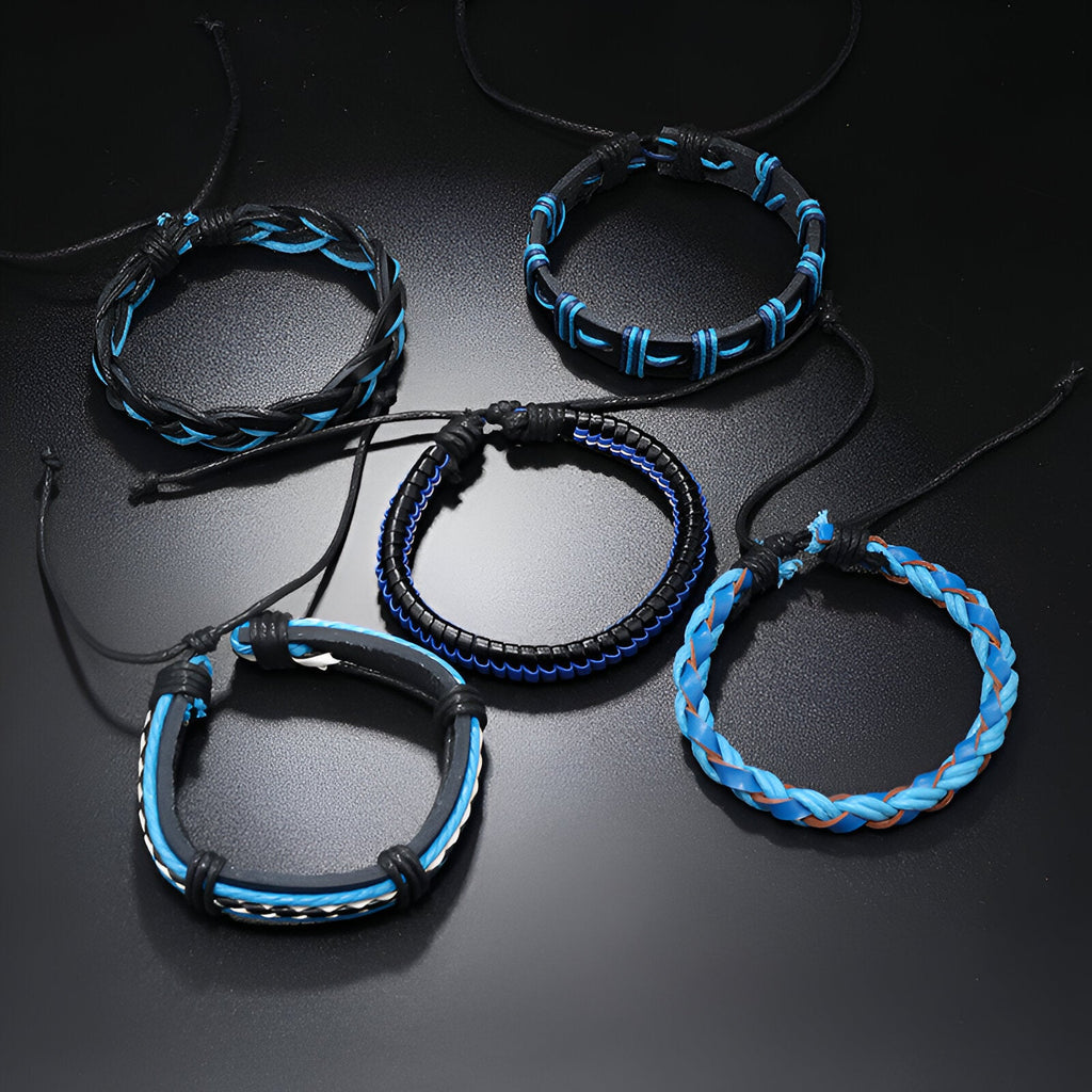 Cinq bracelets mixtes bleus avec cordons tressés et détails noués sur fond noir.