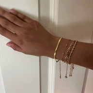 Ensemble de 5 bracelets en acier inoxydable doré, styles variés avec chaînes fines et lisses.