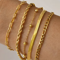 Ensemble de 5 bracelets dorés en acier inoxydable, styles variés, chaînes et perles fines.