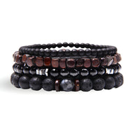 Ensemble de quatre bracelets noirs en bois et pierres volcaniques avec perles mates et brillantes, style homme Milan.
