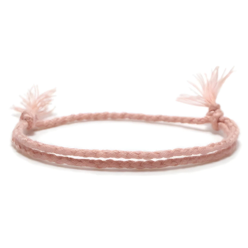 Trio de bracelets tibétains en coton rose clair tressé avec nœuds effilochés aux extrémités.