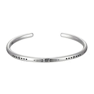 Bracelet jonc ouvert en argent avec motifs gravés, design minimaliste et élégant pour homme.