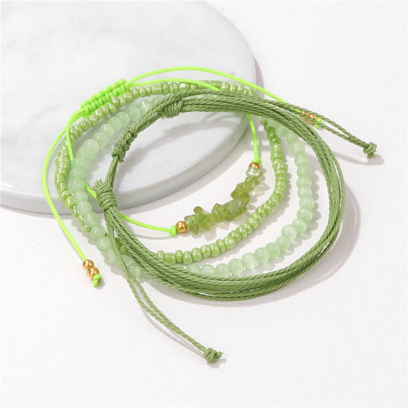 Ensemble de bracelets verts en perles d'aventurine et cordons ajustables tressés, avec petits détails dorés.