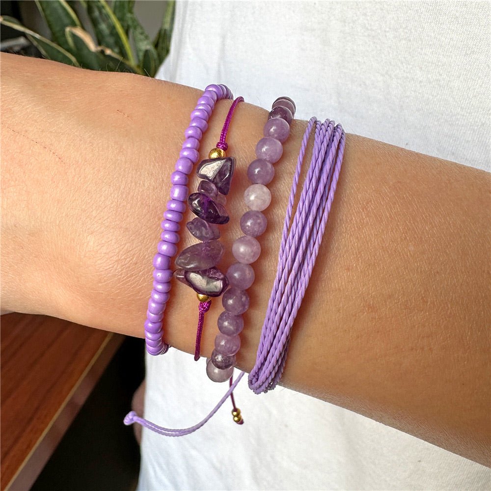 Ensemble de bracelets violets en perles lisses, pierres anguleuses et cordons tressés fins pour femme.