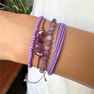 Ensemble de bracelets violets en perles lisses, pierres anguleuses et cordons tressés fins pour femme.