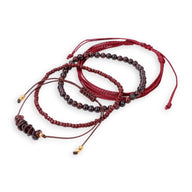 Ensemble de bracelets rouges avec perles en grenat et cordons ajustables en nylon rouge.