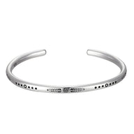 Bracelet tibétain en argent brossé avec gravures fines et motif central orné de lapis lazuli.