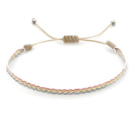 Trio de bracelets tibétains tressés marron, argent et oeil de tigre avec fermeture coulissante.