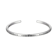 Bracelet tibétain en argent avec gravures fines et détails noirs pour homme, style minimaliste.