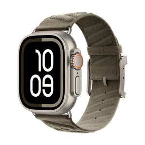 Montre Apple avec boîtier argenté, bracelet tressé vert kaki respirant et boucle métal robuste.