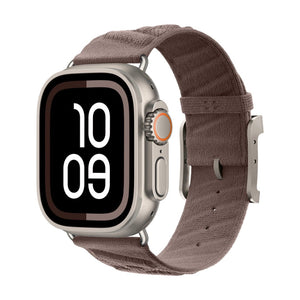 Montre Apple avec bracelet en tissu tressé marron, boucle métallique argentée, design épuré et respirant.