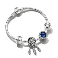 Bracelet argenté avec espaceurs et pendentif attrape-rêves orné d'un zircon bleu rond.