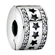 Espaceur en argent avec étoiles découpées et rangées de petits cristaux sur les côtés.